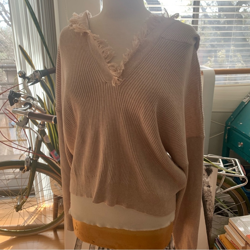 Le Lis v-neck sweater with hoodie and fringe around v-neck and hoodie. Beige/tan